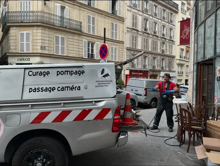 Technicien 3D Assainissement réalisant le curage de la canalisation d'eaux usées d'un restaurant à Paris 17e avec le camion Curage Pompage