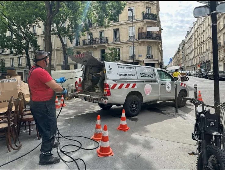 Camion hydrocureur 3D Assainissement en intervention de débouchage devant un restaurant à Paris 17e